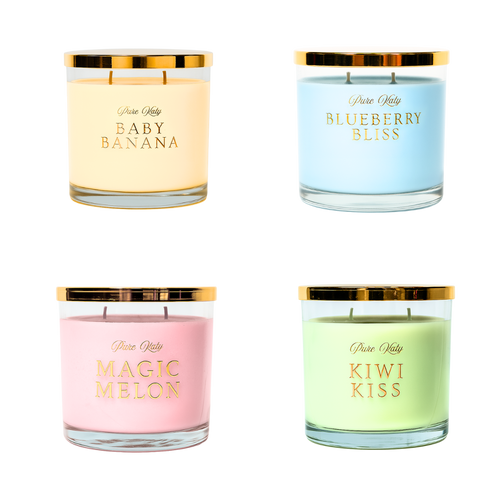 Fünf Duftkerzen der 'Pure Katy'-Kollektion: 'X-MAS Cookies', 'Blueberry Bliss', 'Baby Banana', 'Kiwi Kiss' und 'Magic Melon', pyramidenförmig angeordnet mit goldenen Deckeln, auf festlichem Hintergrund mit schimmernden Lichtpunkten.